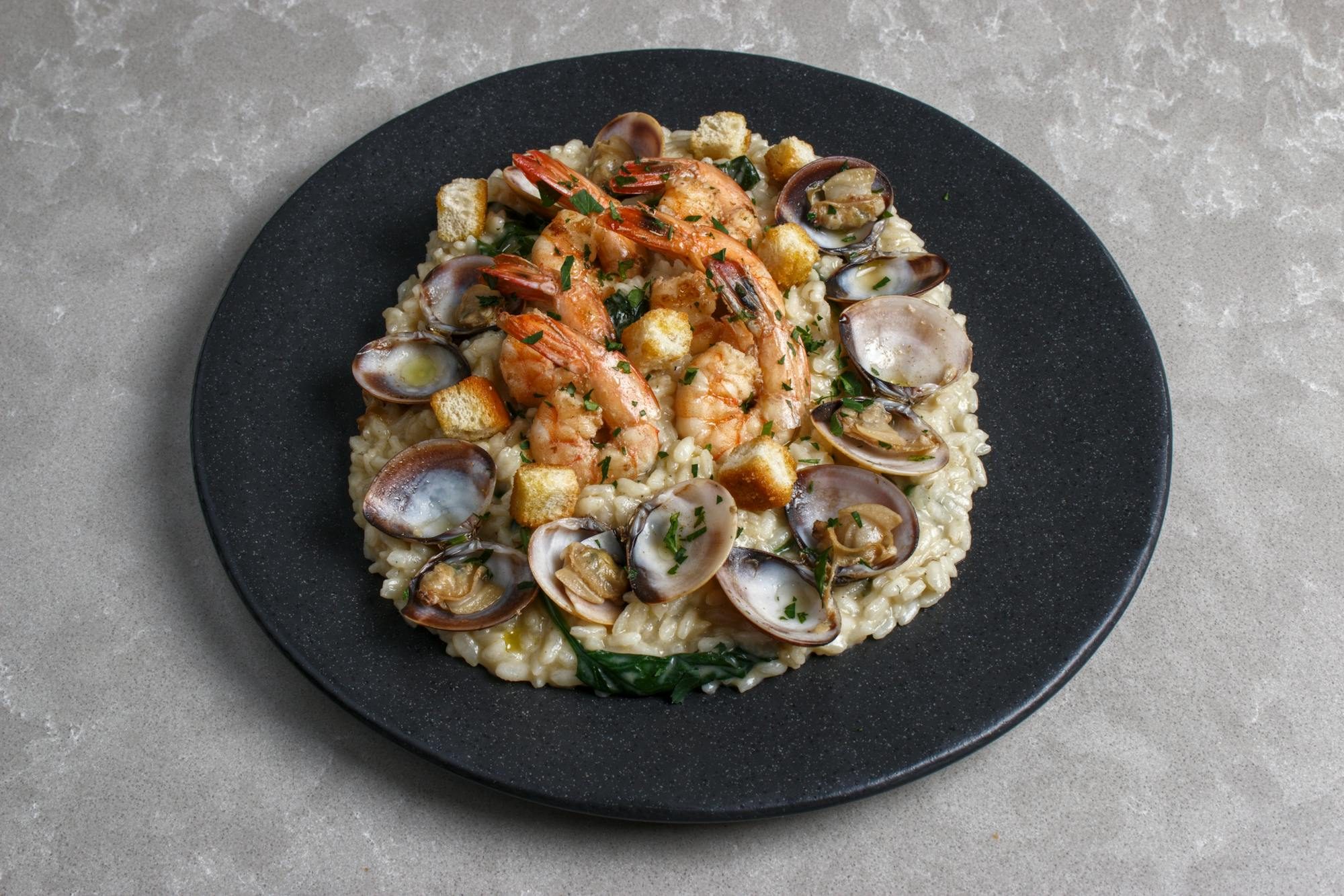 Risotto agli scampi — Carnaroli mantecato al burro d'alpeggio, scampi crudi, zeste di limone.